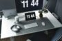 Bureau minimaliste avec écran affichant l’heure, symbole de gestion du temps et de recentrage sur l’essentiel pour les professions libérales