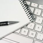 Ordinateur portable affichant des tableaux de bord analytiques sur un bureau clair, symbolisant le les services de secrétariat et gestion administrative à externalisés