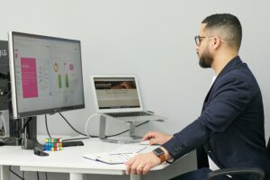 Homme travaillant sur un tableur affichant des graphiques et données, illustrant le nettoyage et la fiabilisation d’un fichier prospects